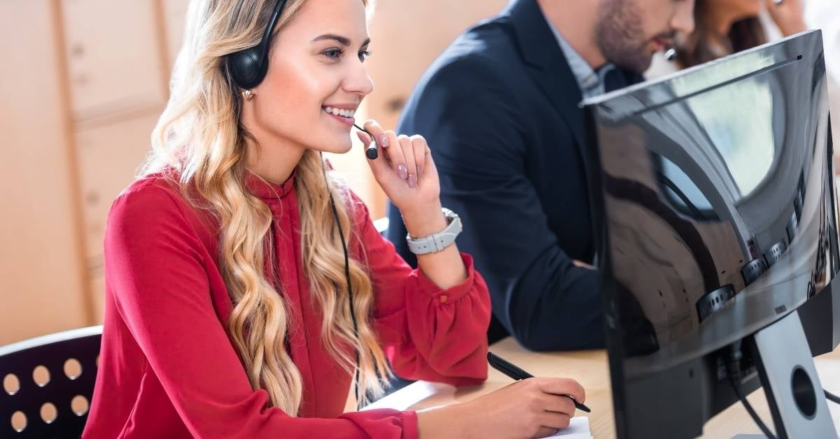 Frau mit Headset an Computer